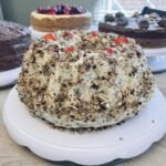 A close-up of a slice of layered chocolate cake on a plate, served at the Giftly Surprize coffee shop.