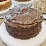A close-up of a slice of layered chocolate cake on a plate, served at the Giftly Surprize coffee shop.